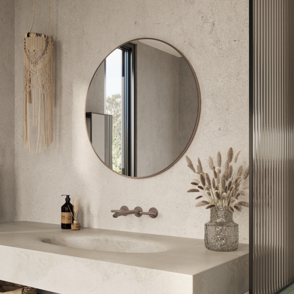 Lifestyle Image of the Origins Living Docklands 800mm x 800m Brushed Bronze Round Mirror mounted on a cream bathroom wall in front of a modern style basin DKL-00D080-BZ